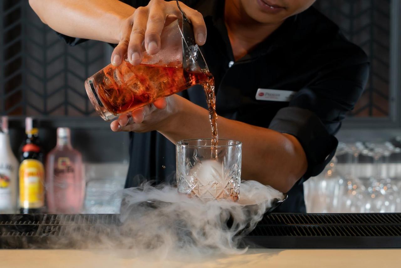 Bayphere Hotel Pattaya Jc Na Chom Thian Bagian luar foto A bartender pouring a cocktail
